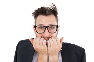 Geeky nervous businessman looking at camera on white background